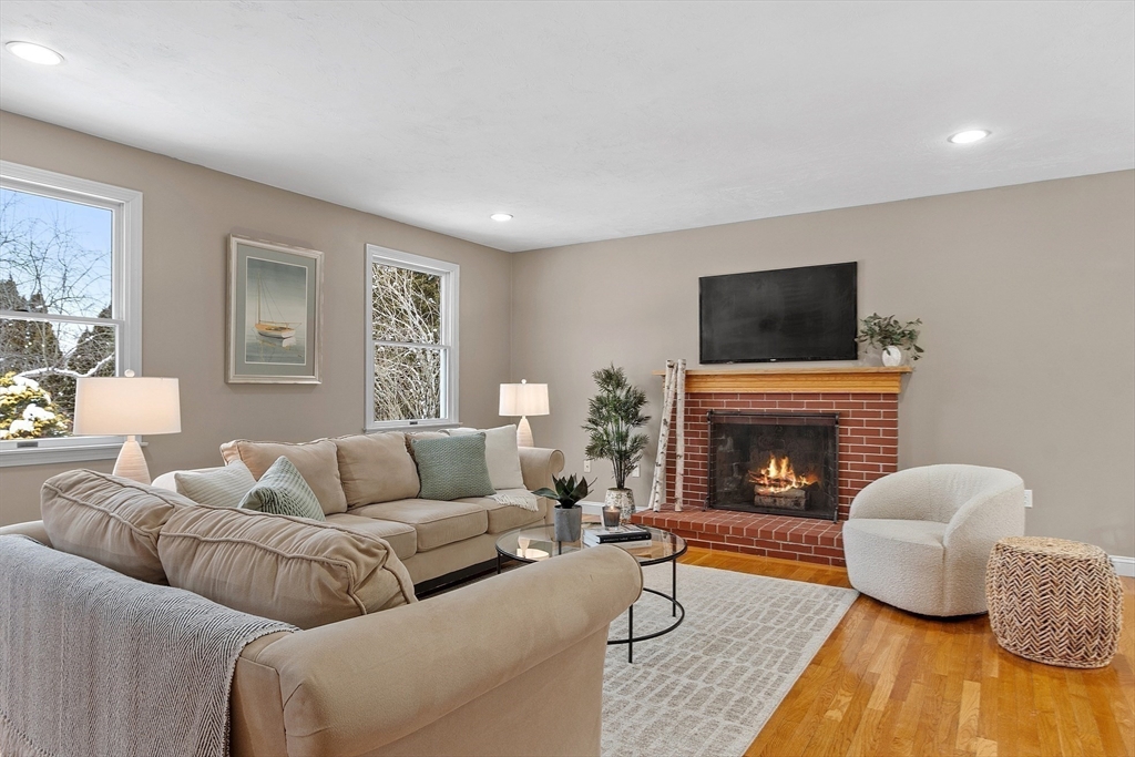 30 Duck Road Reading, MA 01867 - Photo 6 of 42 a living room with furniture a fireplace and a flat screen tv