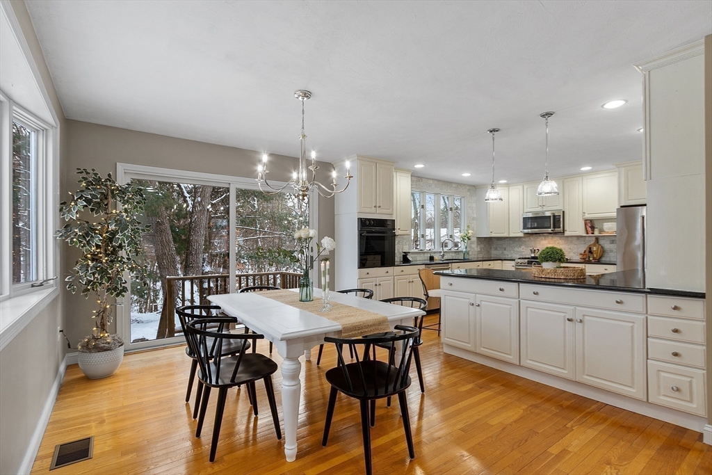 30 Duck Road Reading, MA 01867 - Photo 9 of 42 a kitchen with stainless steel appliances granite countertop a dining table chairs and white cabinets