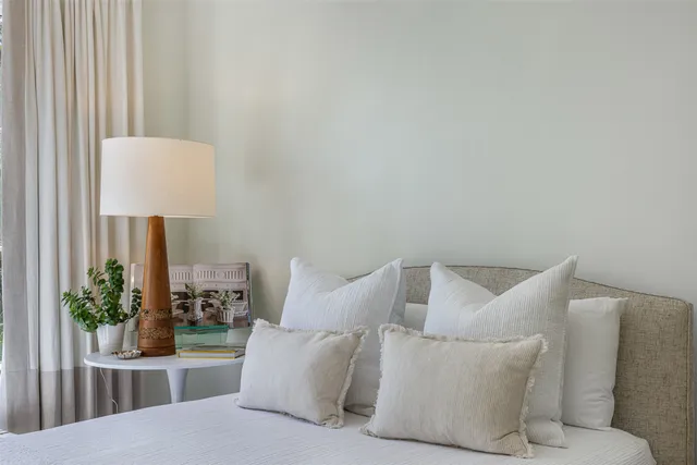 a bedroom with a bed and a lamp with potted plant