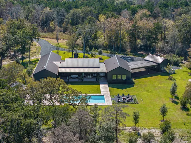 an aerial view of a house with swimming pool garden and patio