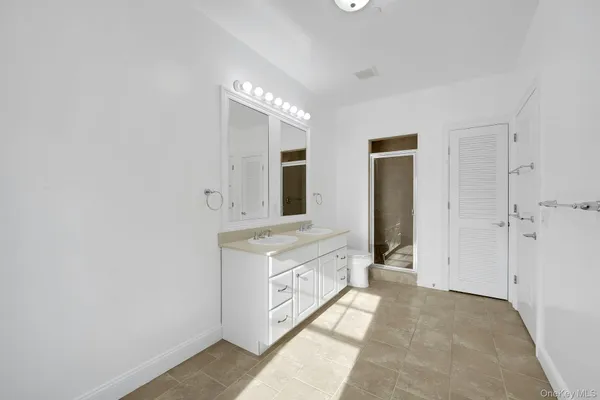 a bathroom with a double vanity sink and a mirror