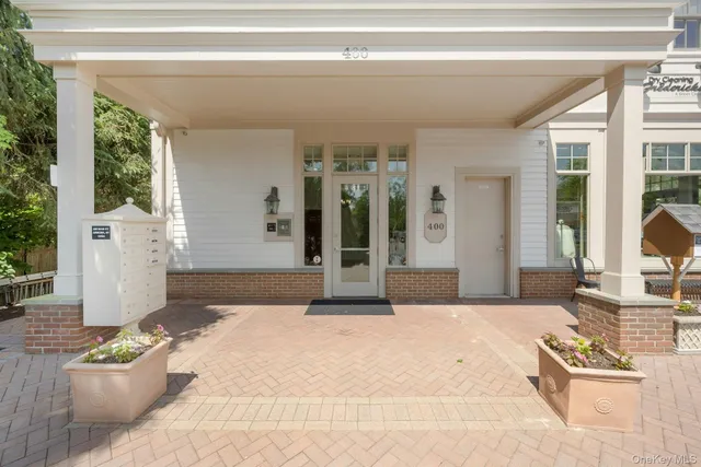 a spacious bedroom with a large window and a chandelier
