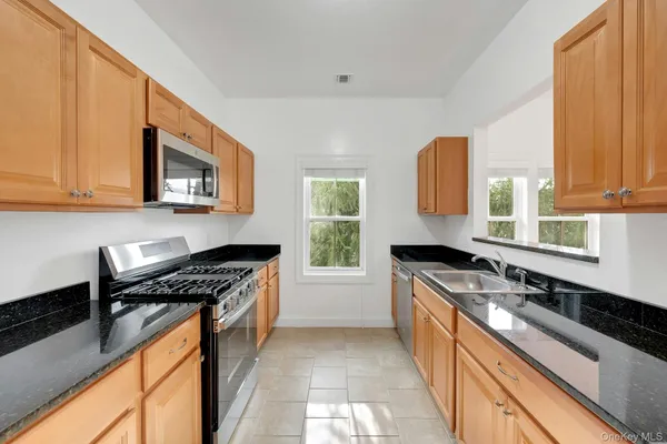 a kitchen with a sink stove top oven and cabinets