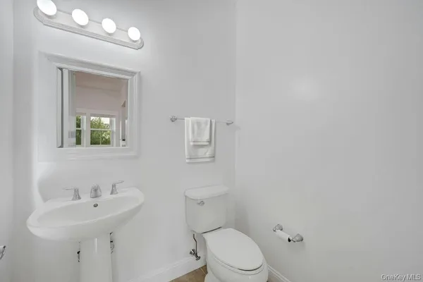 a bathroom with a toilet a sink and mirror