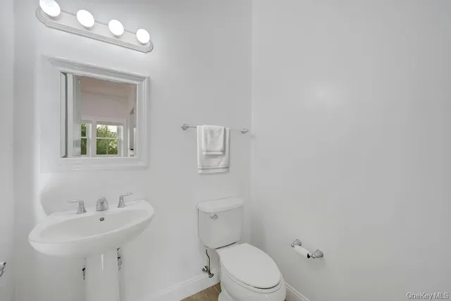 a bathroom with a toilet a sink and mirror
