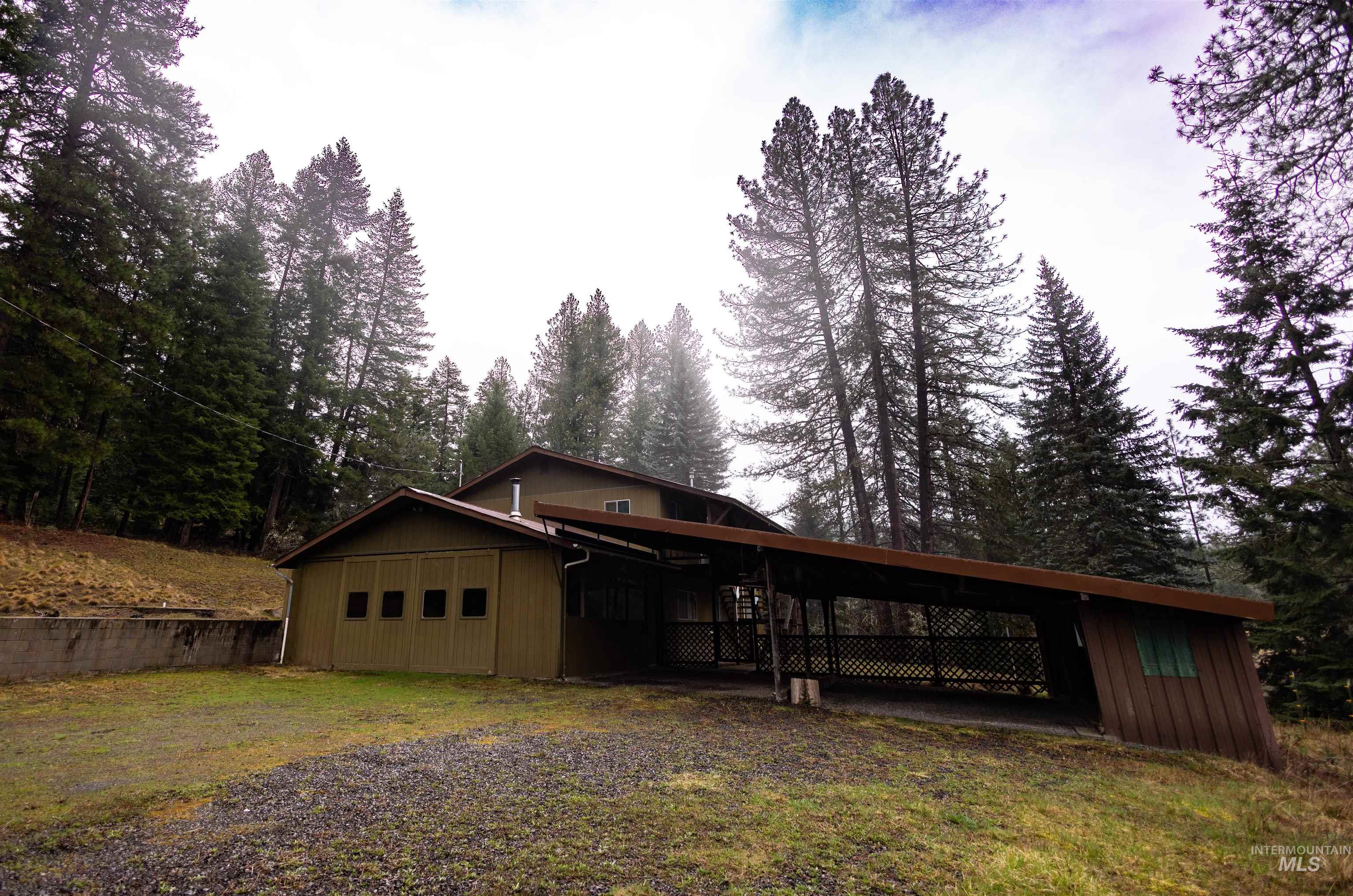 717 Big Cedar Road Kooskia, ID 83539 - Photo 1 of 50 View of front facade featuring a front lawn, an attached carport, and a wooden deck