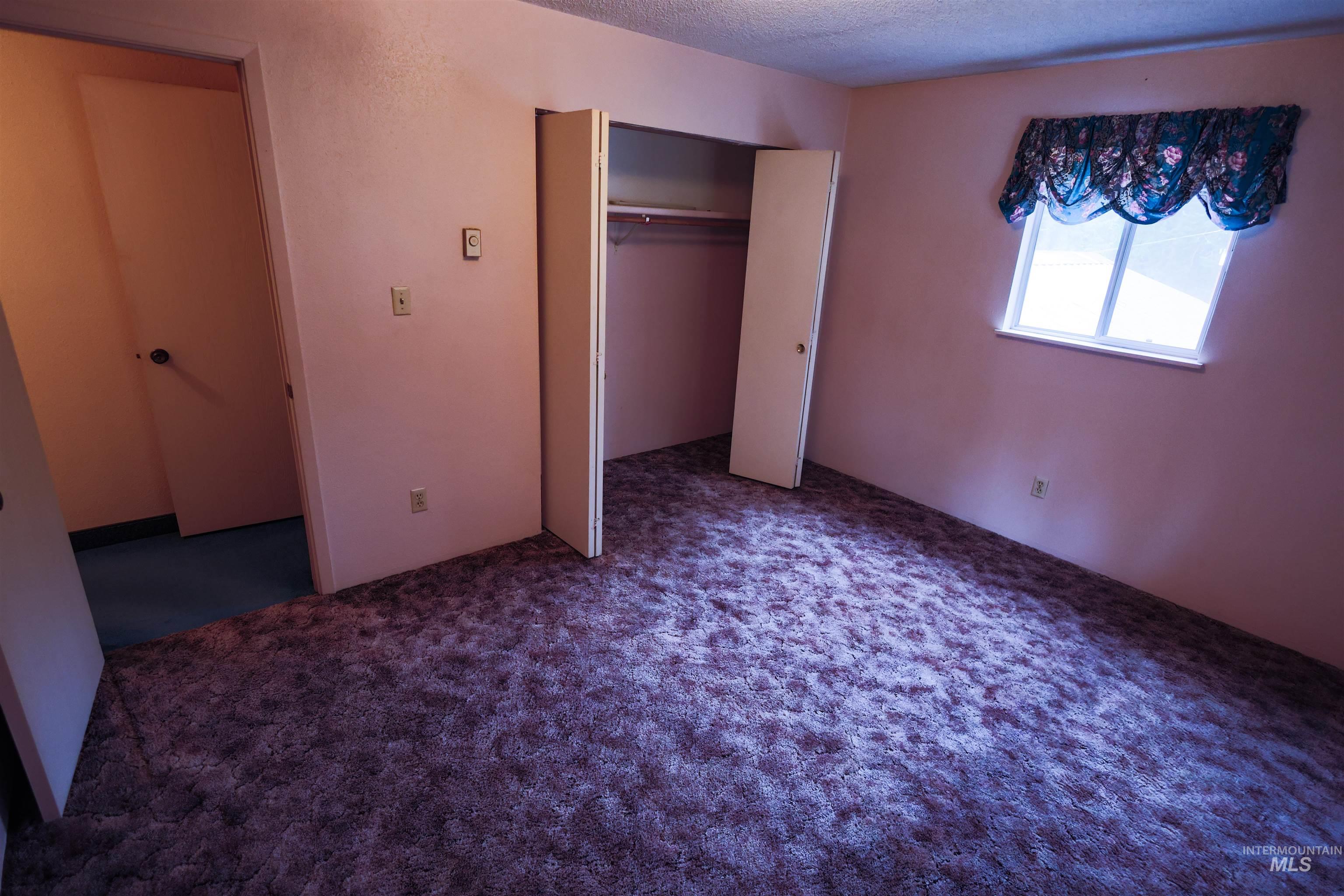 717 Big Cedar Road Kooskia, ID 83539 - Photo 11 of 50 Unfurnished bedroom featuring a closet, carpet flooring, and a textured ceiling