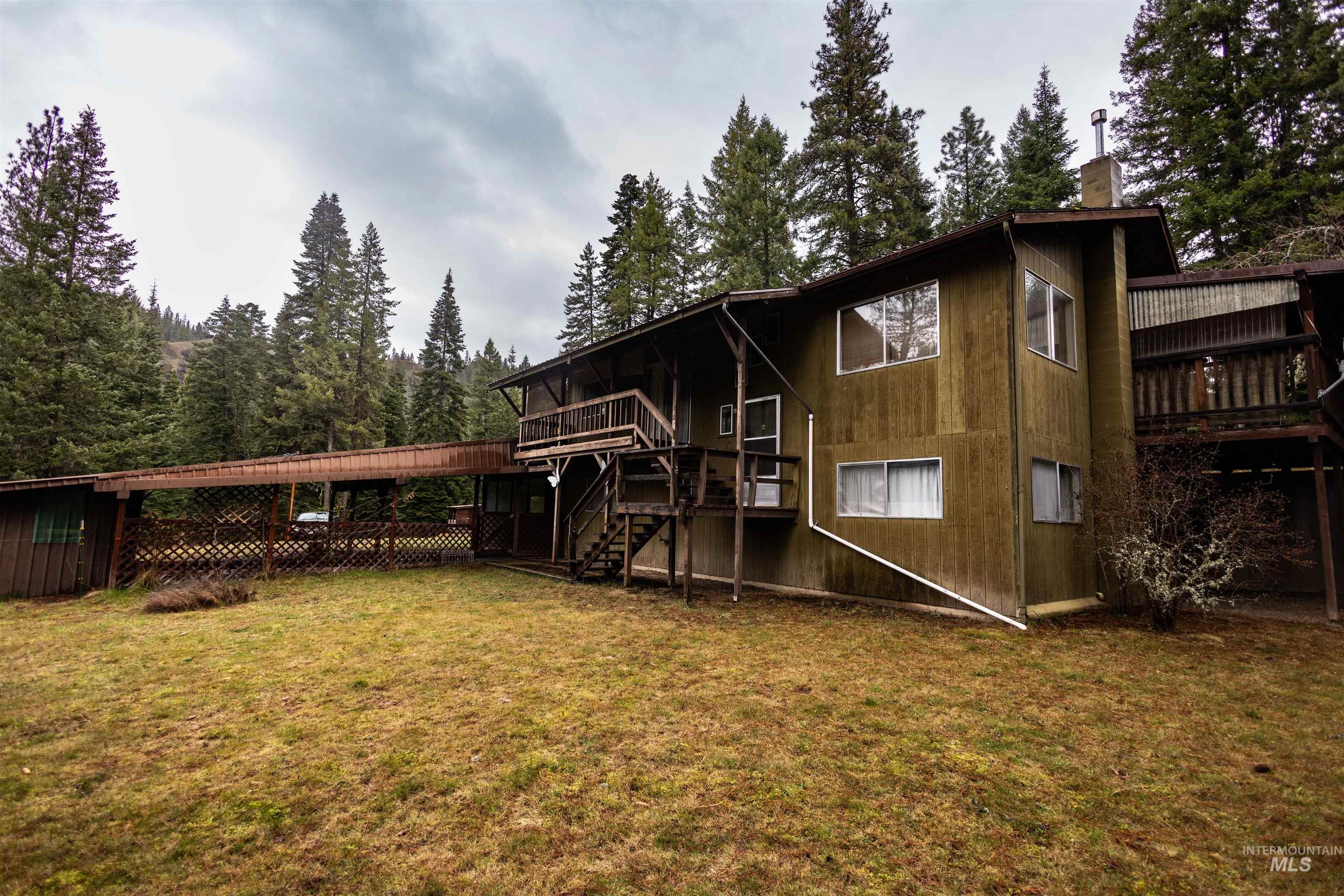 717 Big Cedar Road Kooskia, ID 83539 - Photo 28 of 50 Rear view of property featuring a deck, a lawn, a chimney, and a sunroom