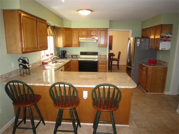 112 Sibley Road Waltham, MA 02453 - Photo 3 of 20 a kitchen with stainless steel appliances granite countertop a dining table chairs refrigerator and sink