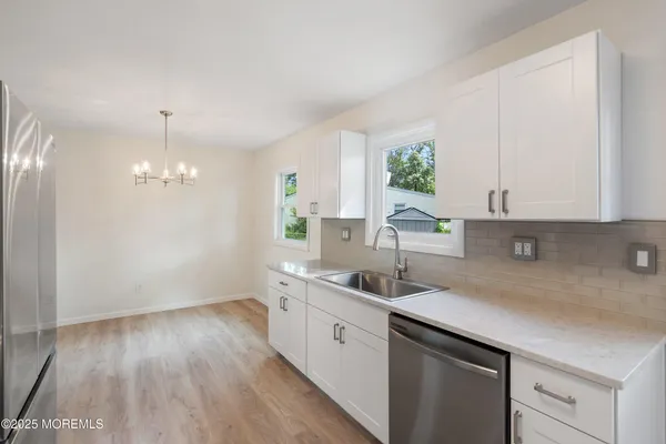 a kitchen with a sink a window and cabinets