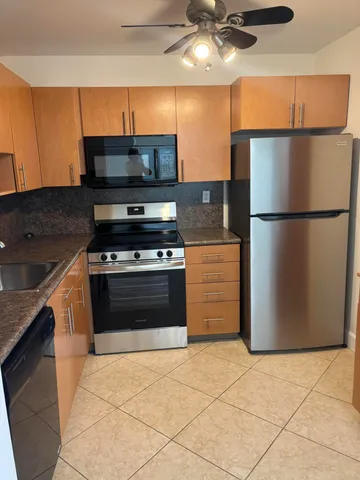 a kitchen with a refrigerator and a stove top oven