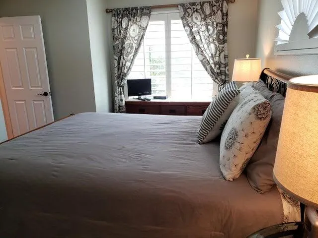 a view of a bedroom with a bed and large windows