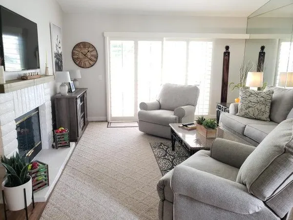 a living room with furniture a flat screen tv and a fireplace