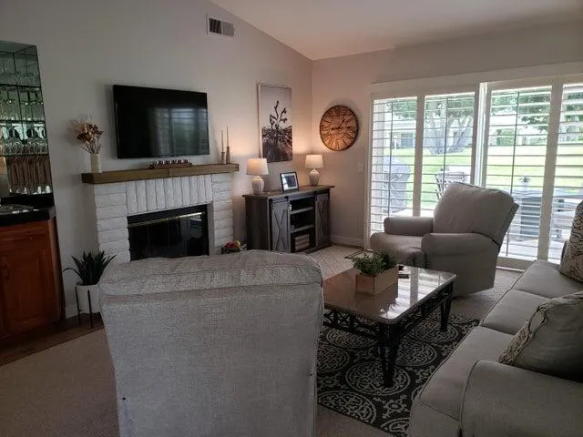 a living room with furniture a flat screen tv and a fireplace