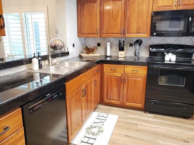 a kitchen with stainless steel appliances granite countertop a sink stove and microwave