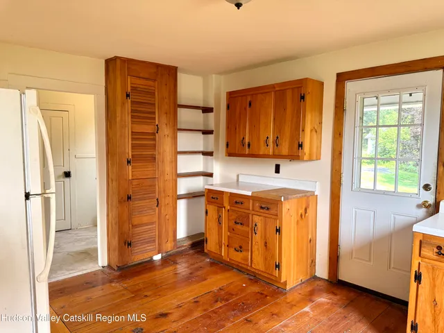 a view of a kitchen with wooden floor and electronic appliances
