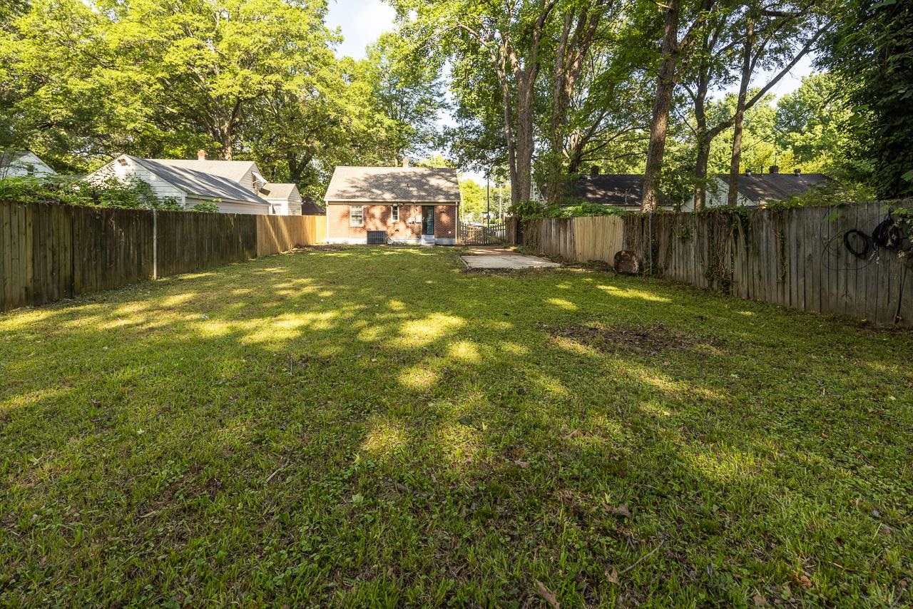 730 Shotwell Street Memphis, TN 38111 - Photo 18 of 20 a backyard of a house with table and chairs and wooden fence