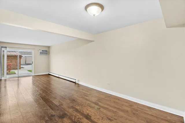 a view of a kitchen with wooden floor and a window