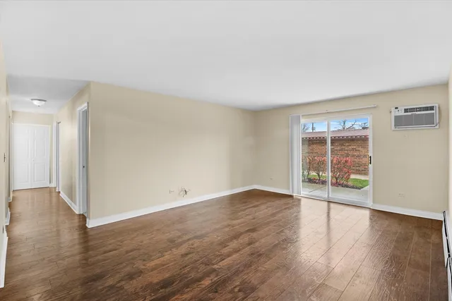 an empty room with wooden floor and window