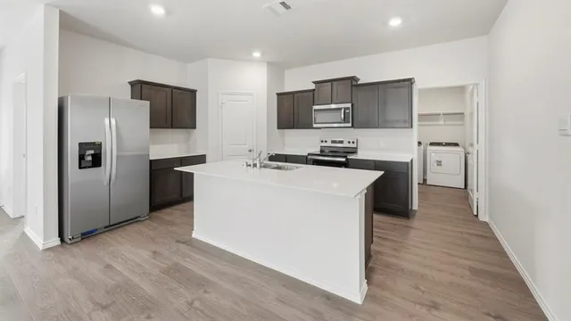 a kitchen with cabinets a sink and stainless steel appliances