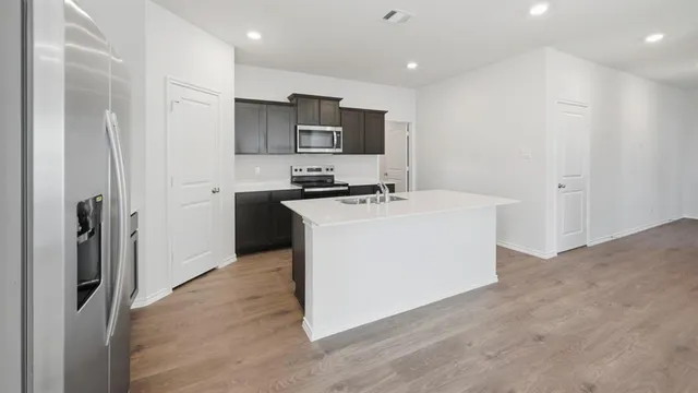 a kitchen with stainless steel appliances a sink stove and refrigerator