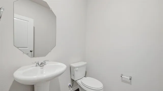 a bathroom with a sink a toilet and mirror
