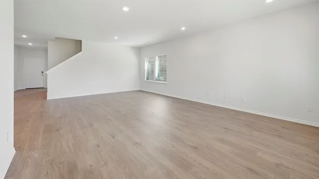 a view of an empty room with wooden floor