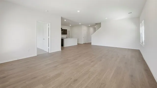 wooden floor in an empty room with a kitchen
