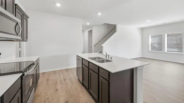 a kitchen with a sink a window and wooden floor