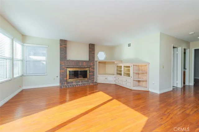 a view of a livingroom with wooden floor and a fireplace