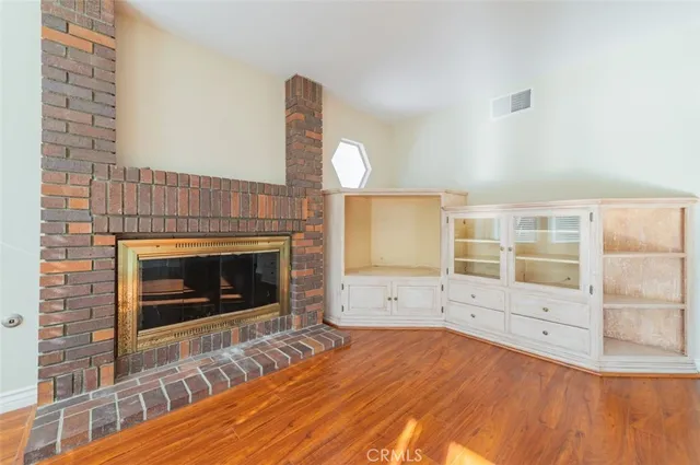 a view of empty room with wooden floor and fireplace