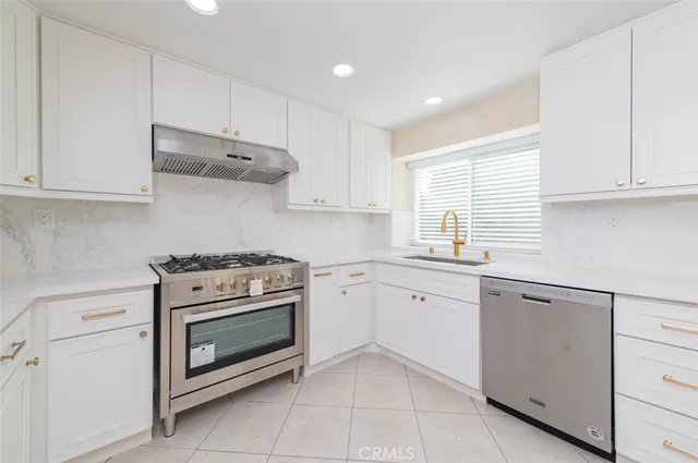a kitchen with cabinets appliances and a sink