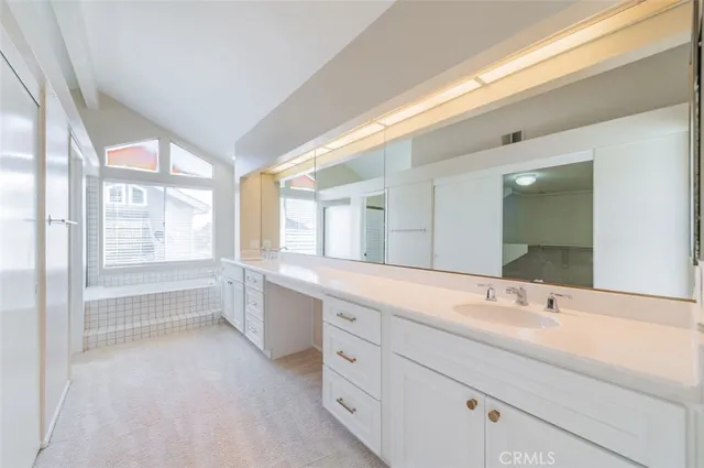 a spacious bathroom with double vanity and a large mirror