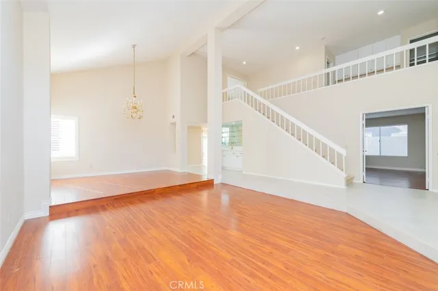a view of an empty room with wooden floor and entryway