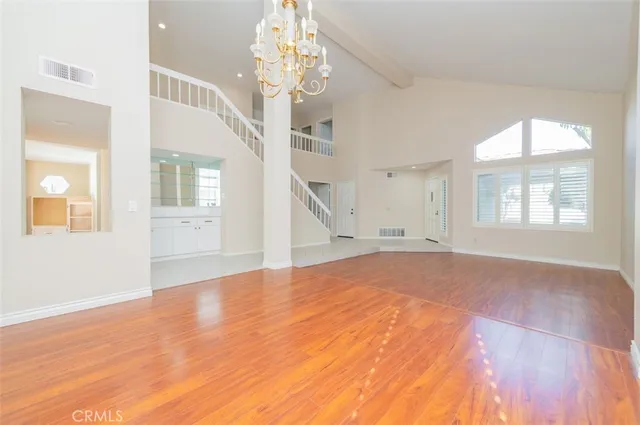 a view of empty room with wooden floor and windows