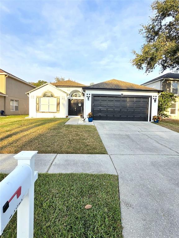 24921 Ravello Street Land O Lakes, FL 34639 - Photo 13 of 36 a front view of a house with a yard and garage