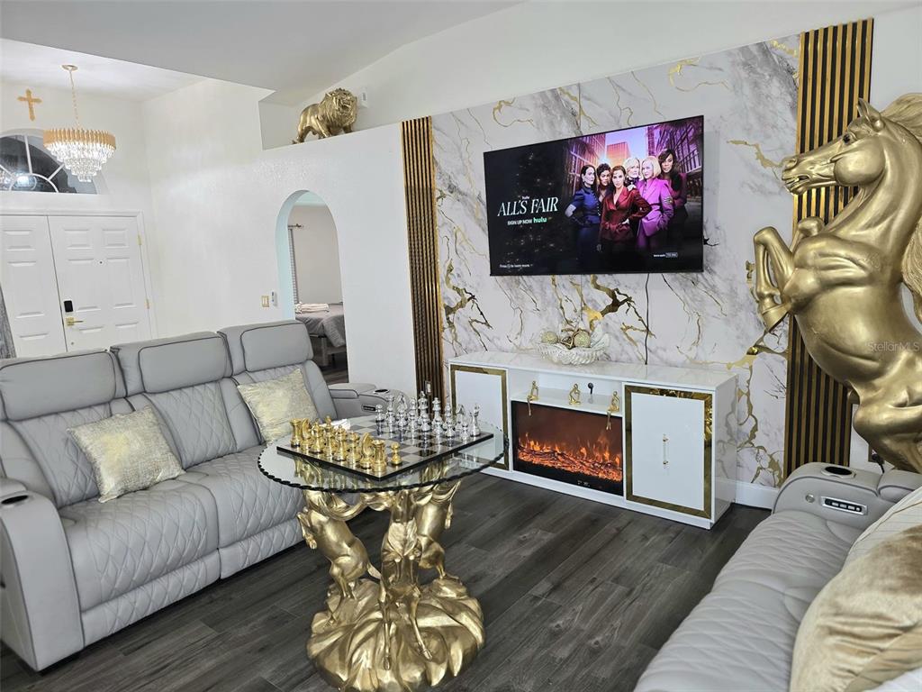 24921 Ravello Street Land O Lakes, FL 34639 - Photo 14 of 36 a living room with furniture a flat screen tv and a fireplace