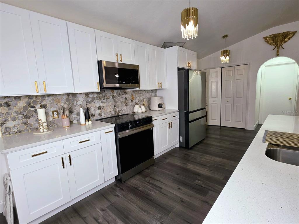 24921 Ravello Street Land O Lakes, FL 34639 - Photo 15 of 36 a kitchen with granite countertop a refrigerator stove top oven and sink