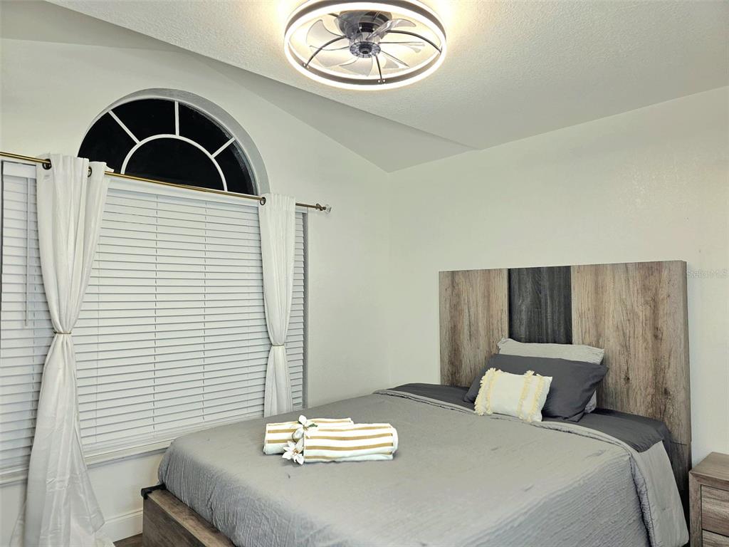 24921 Ravello Street Land O Lakes, FL 34639 - Photo 17 of 36 a bedroom with a bed and a chandelier