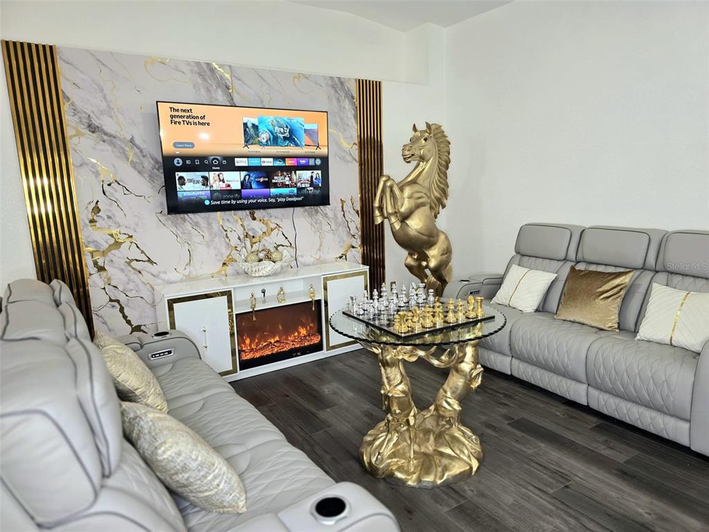 24921 Ravello Street Land O Lakes, FL 34639 - Photo 27 of 36 a living room with furniture a fireplace and a flat screen tv