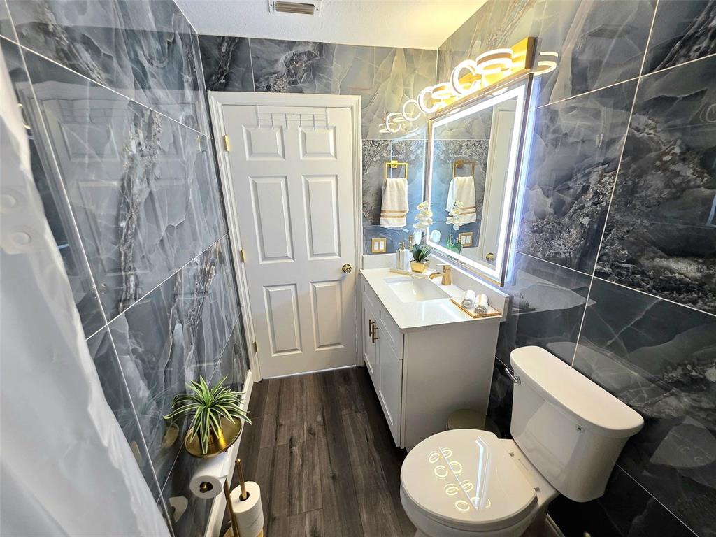 24921 Ravello Street Land O Lakes, FL 34639 - Photo 31 of 36 a white toilet sitting next to a bathroom sink and a shower