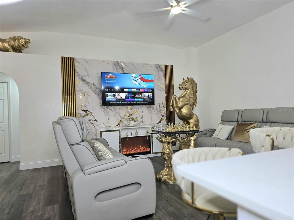 24921 Ravello Street Land O Lakes, FL 34639 - Photo 36 of 36 a living room with furniture a flat screen tv and a wall painting