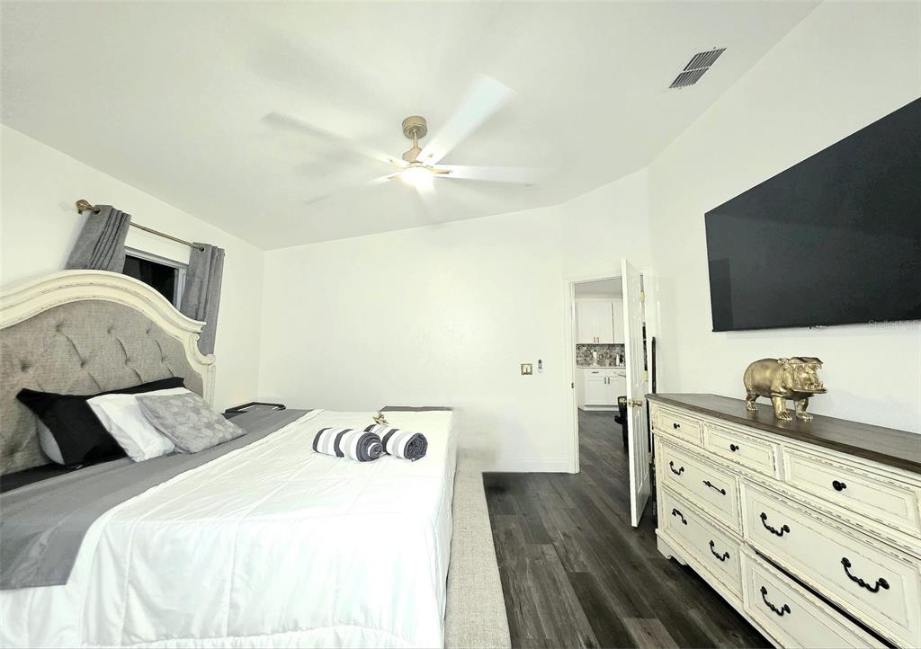 24921 Ravello Street Land O Lakes, FL 34639 - Photo 6 of 36 a spacious bedroom with a bed and a flat screen tv