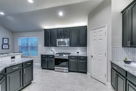 a kitchen with stainless steel appliances granite countertop a stove sink and cabinets