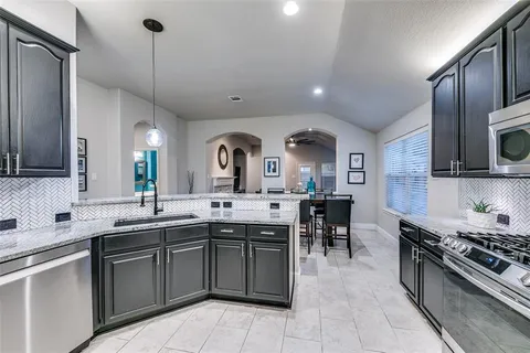 a kitchen with lots of counter top space sink and stainless steel appliances