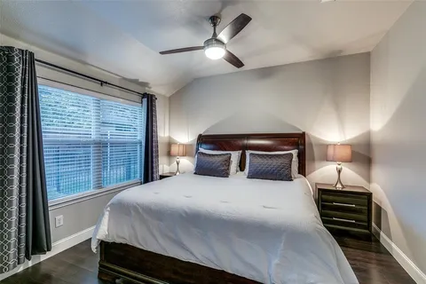 a bedroom with a large bed and a ceiling fan