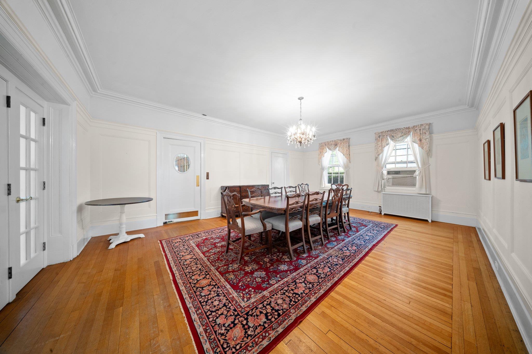 10-08 Shore Road Queens, NY 11363 - Photo 12 of 47 a dining room with wooden floor and chandelier