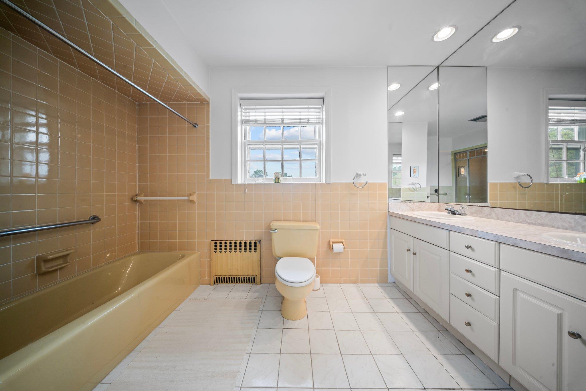 10-08 Shore Road Queens, NY 11363 - Photo 22 of 47 a spacious bathroom with a granite countertop sink toilet a large mirror a bathtub and window
