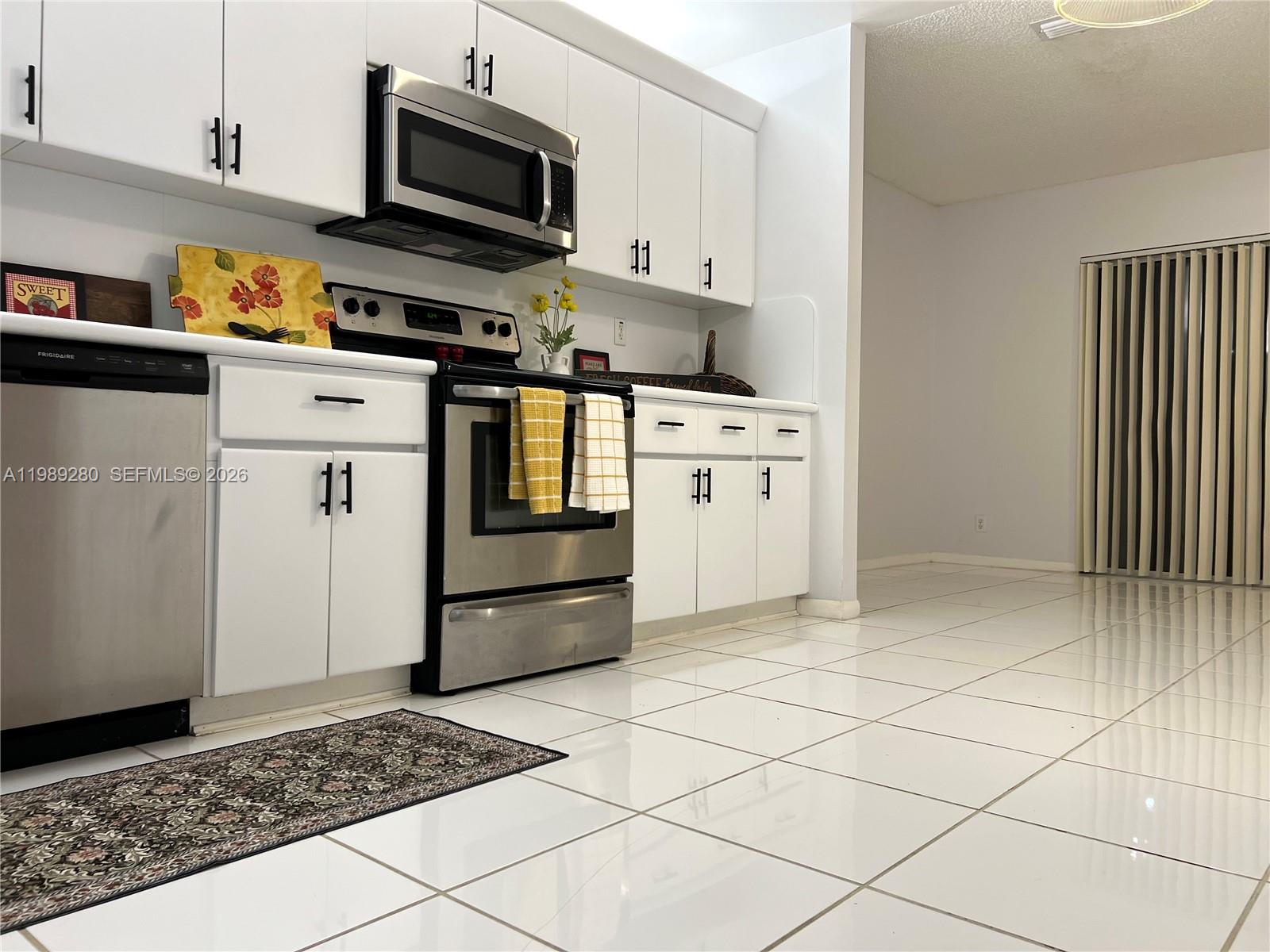 543 Racquet Club Road, Unit 33 Weston, FL 33326 - Photo 8 of 28 a kitchen with stainless steel appliances a refrigerator sink and microwave