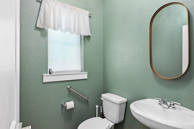 a bathroom with a toilet sink and mirror